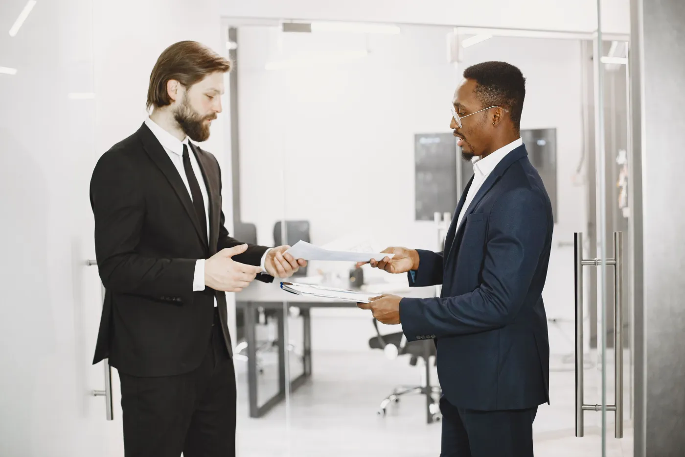 Two professionals exchanging legal documents in an office