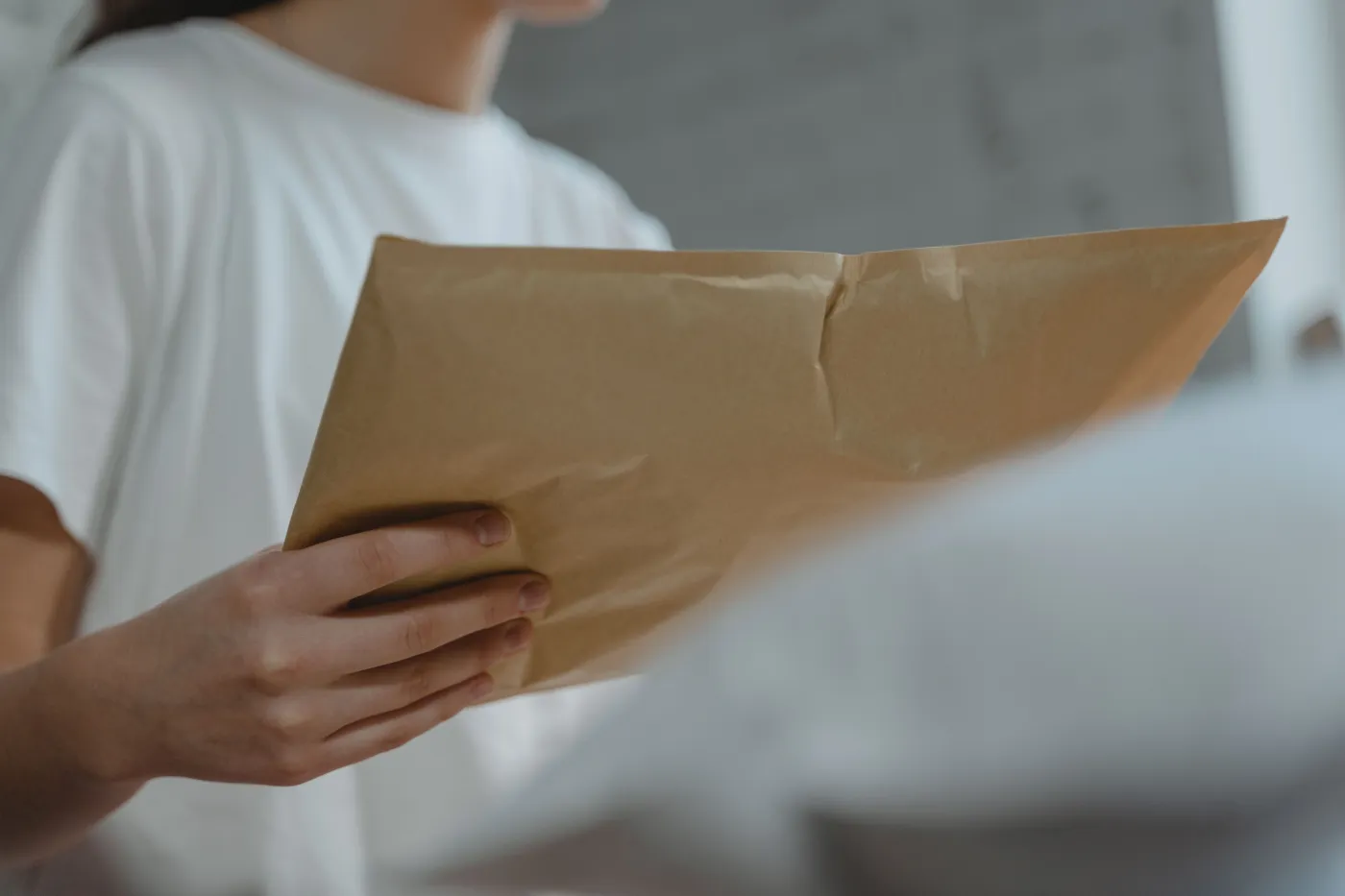 Person holding a sealed business mail envelope