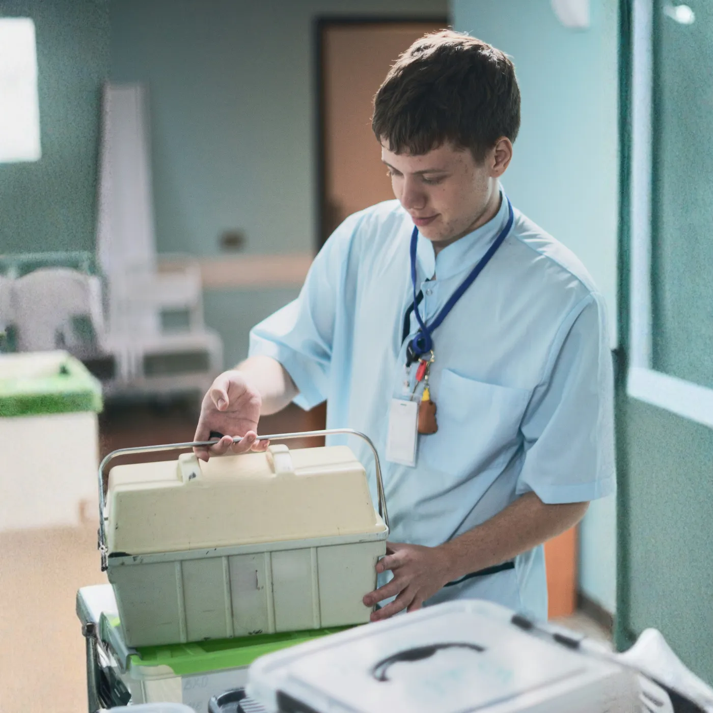 Healthcare courier collecting a sealed specimen transport case at a laboratory receiving desk